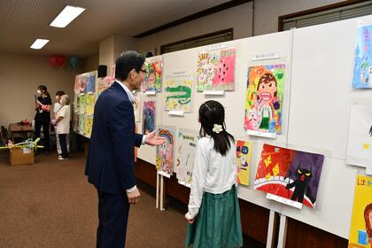 台東区歯科医師会館会場（台東区歯科医師会）で入選作品を観る区長の様子